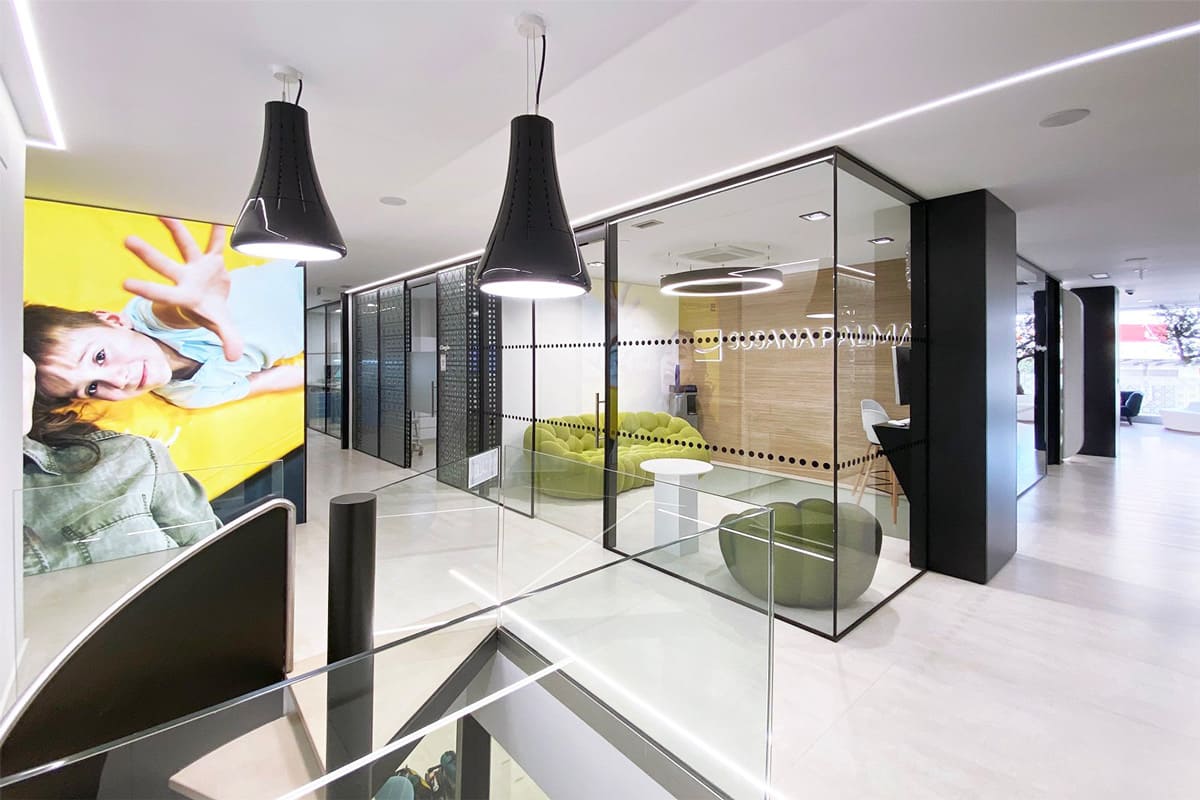 Pasillo de una oficina con divisiones modulares con mampara y puertas de cristal